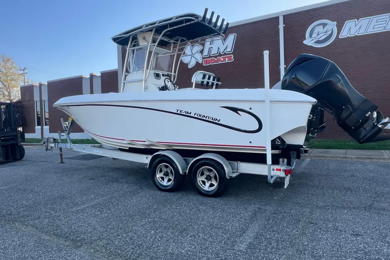 Slide: The Image of 2006 Fountain 23 Center Console boat on trailer, parked outside HM Boats building. - 2