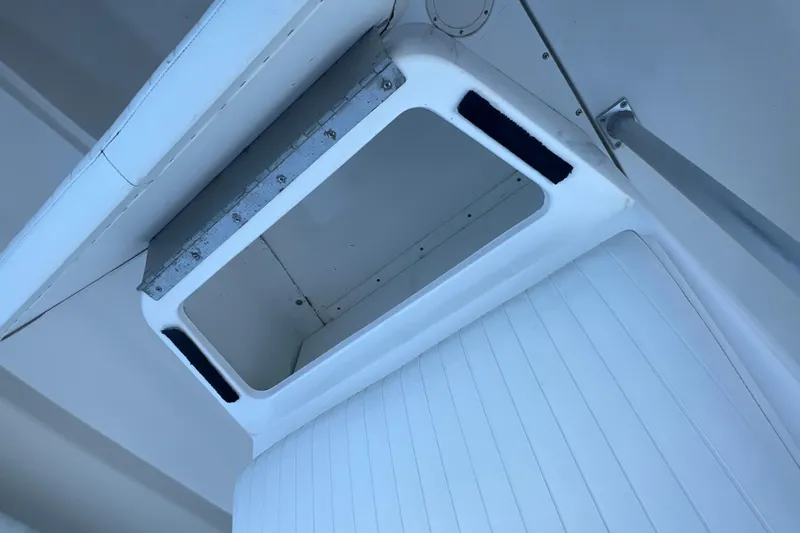 Slide: The Image of Storage compartment on a 2006 Fountain 23 Center Console boat, featuring white interior. - 22