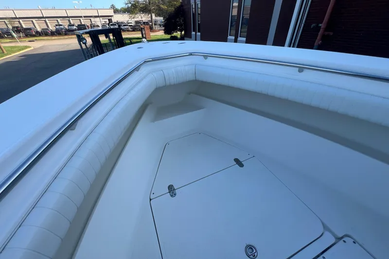 Slide: The Image of 2006 Fountain 23 Center Console boat interior with white cushioned seating and storage compartment. - 32
