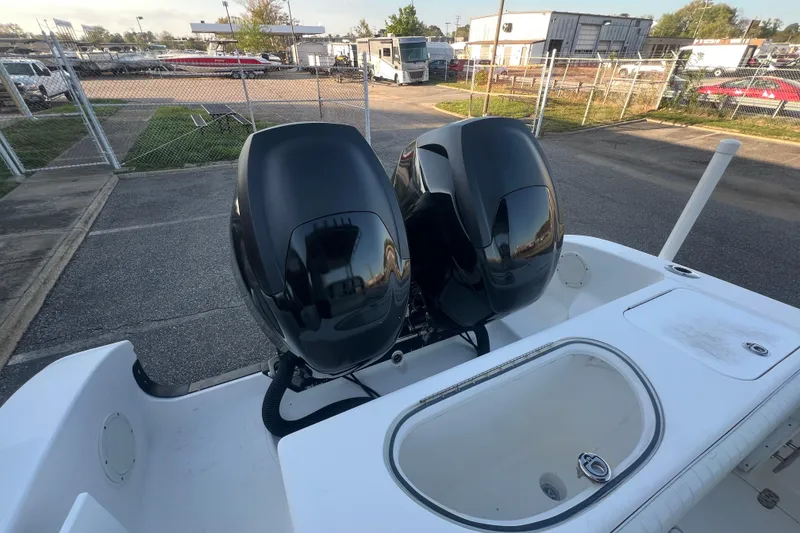 Slide: The Image of 2006 Fountain 23 Center Console boat with dual outboard motors in a marina setting. - 52