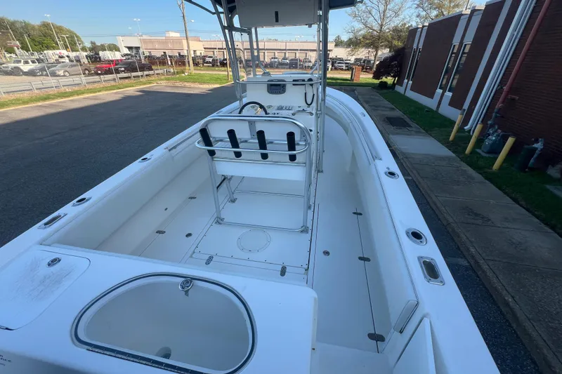 Slide: The Image of 2006 Fountain 23 Center Console boat with spacious deck and seating, parked outdoors. - 54
