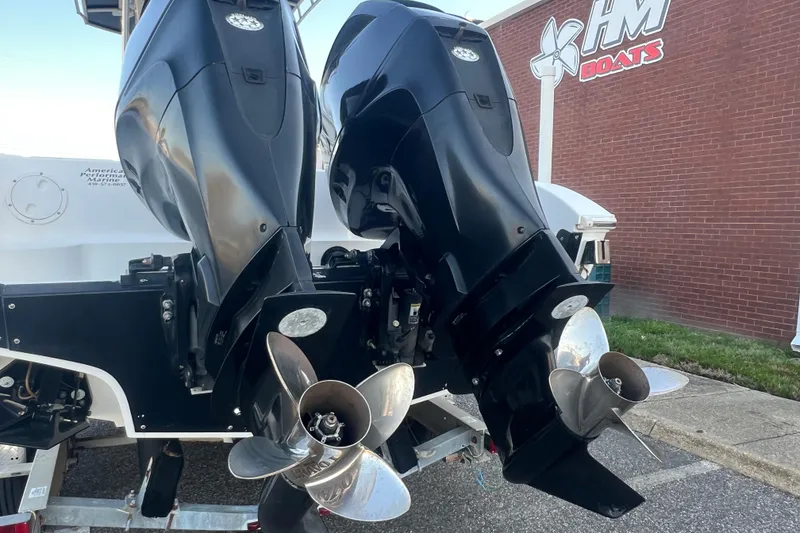 Slide: The Image of Twin outboard motors on a 2006 Fountain 23 Center Console boat, parked near a brick building. - 57