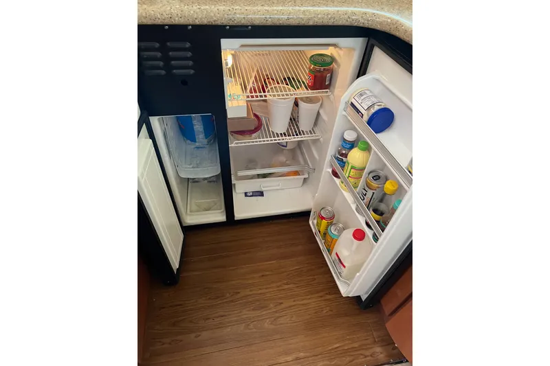 Slide: The Image of Open refrigerator on 2006 Silverton 38 Sport Bridge, stocked with beverages and condiments. - 10