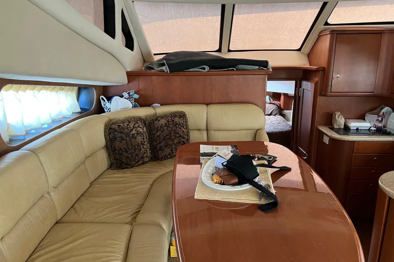 Slide: The Image of Interior of 2006 Silverton 38 Sport Bridge yacht with beige seating and wooden accents. - 14