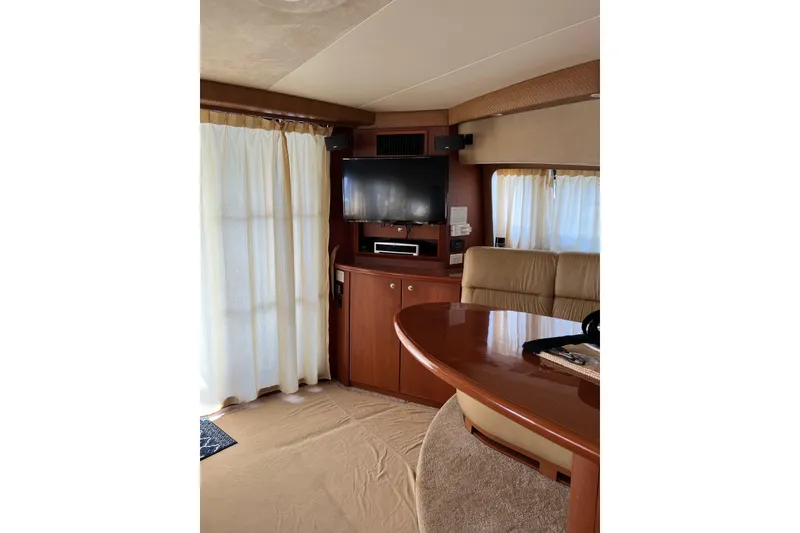 Slide: The Image of Interior of 2006 Silverton 38 Sport Bridge with TV, curtains, and seating area. - 18