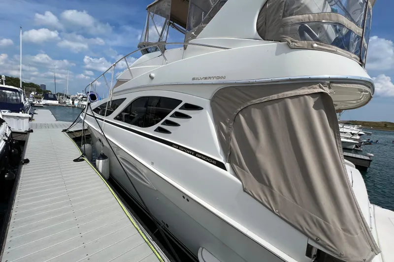 Slide: The Image of 2006 Silverton 38 Sport Bridge yacht docked at marina under blue sky. - 26