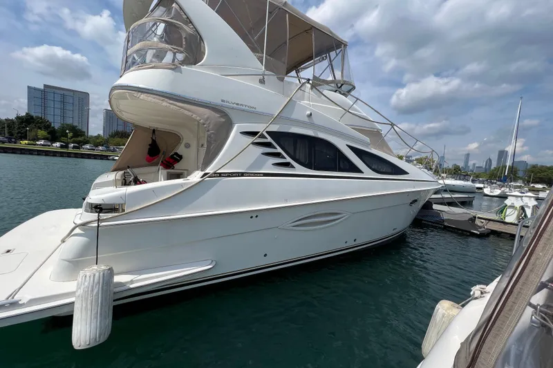 Slide: The Image of 2006 Silverton 38 Sport Bridge yacht docked in marina, city skyline in background. - 27
