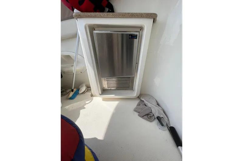 Slide: The Image of Compact refrigerator on 2006 Silverton 38 Sport Bridge yacht, with cleaning supplies nearby. - 28