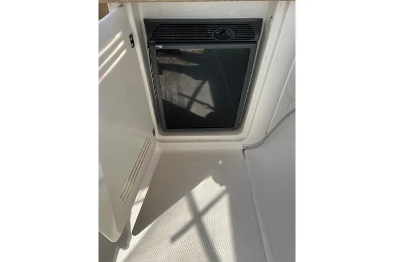 Slide: The Image of 2006 Silverton 38 Sport Bridge interior with open cabinet and built-in mini fridge. - 4