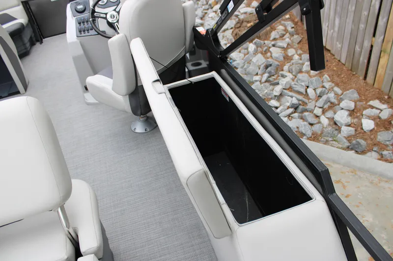 Slide: The Image of 2023 SunChaser Geneva Sport 23 SB boat interior with open storage compartment and steering console. - 14
