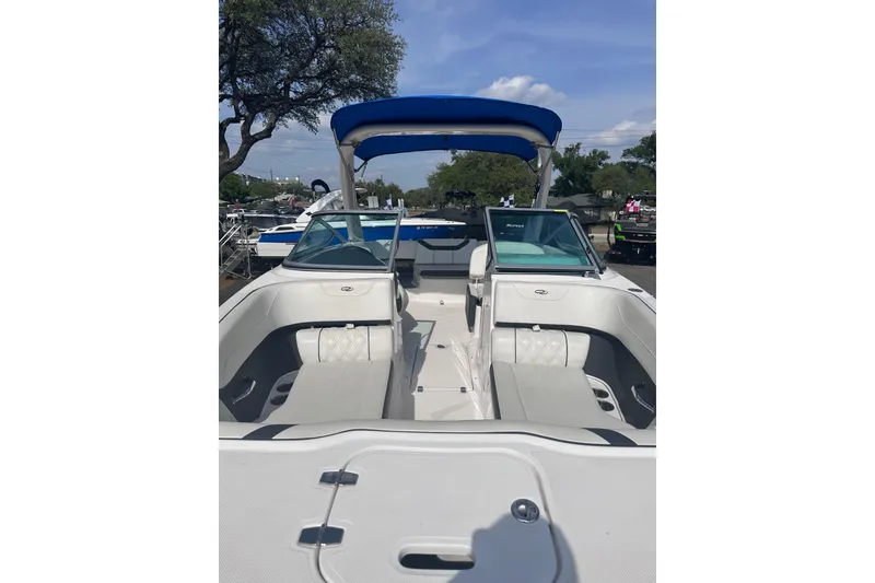 Slide: The Image of 2018 Regal 22 FasDeck boat with blue canopy and spacious seating. - 11