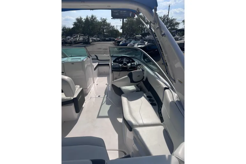 Slide: The Image of 2018 Regal 22 FasDeck boat interior with seating and steering wheel, parked outdoors. - 15