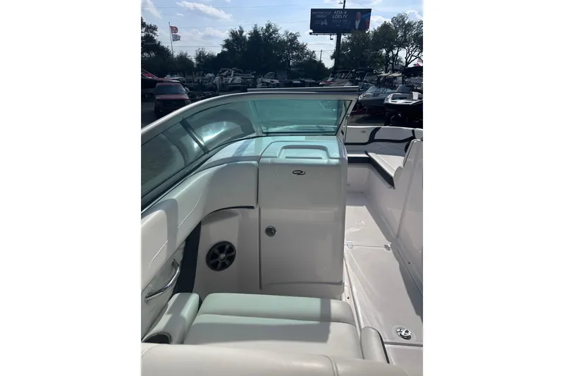 Slide: The Image of 2018 Regal 22 FasDeck boat interior with seating and windshield, under sunny skies. - 18