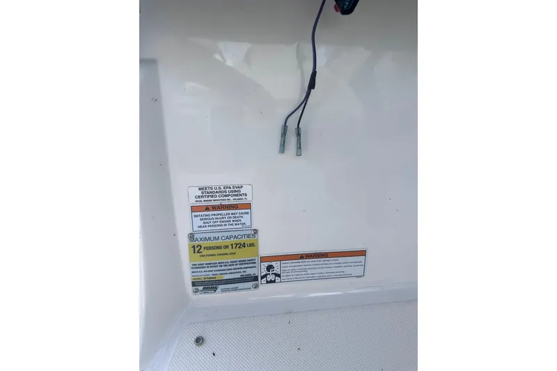 Slide: The Image of Warning labels and capacity information on a 2018 Regal 22 FasDeck boat. - 22