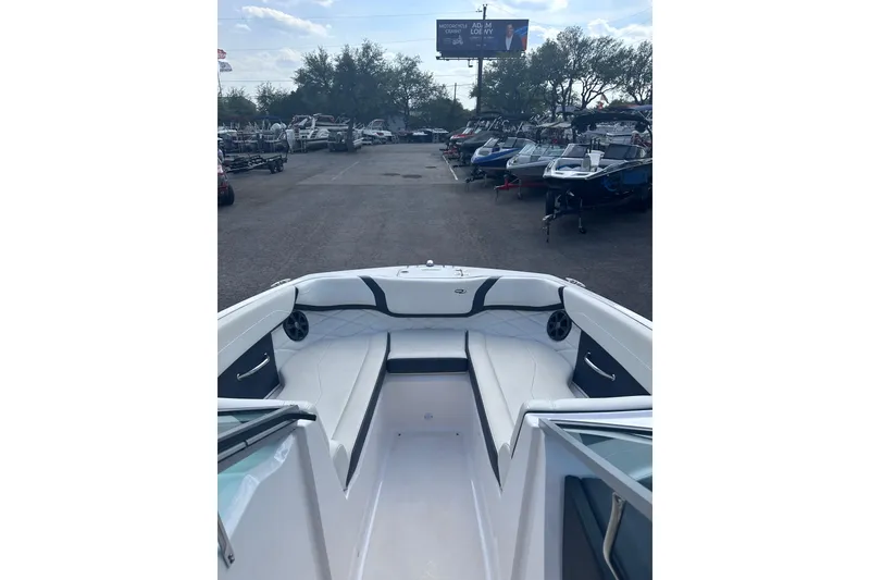 Slide: The Image of 2018 Regal 22 FasDeck boat interior with white seating, parked among other boats. - 23