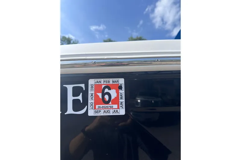 Slide: The Image of 2018 Regal 22 FasDeck boat registration sticker with June expiration under a clear blue sky. - 3