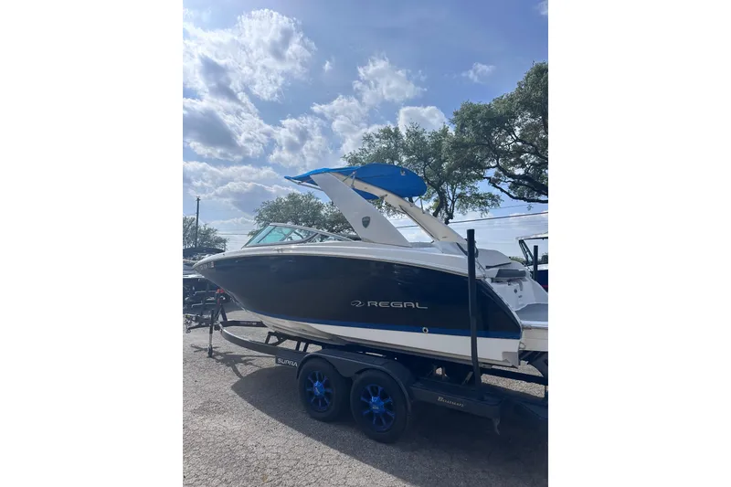 Slide: The Image of 2018 Regal 22 FasDeck boat on trailer under a partly cloudy sky. - 4