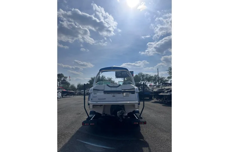 Slide: The Image of 2018 Regal 22 FasDeck boat under a bright, sunny sky in a marina. - 5