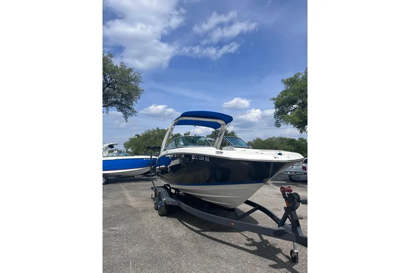 Slide: The Image of 2018 Regal 22 FasDeck boat on trailer under blue sky. - 9