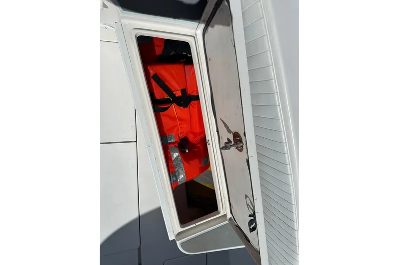 Slide: The Image of Open storage compartment on 2008 Contender 31 Tournament boat with orange life jackets inside. - 10