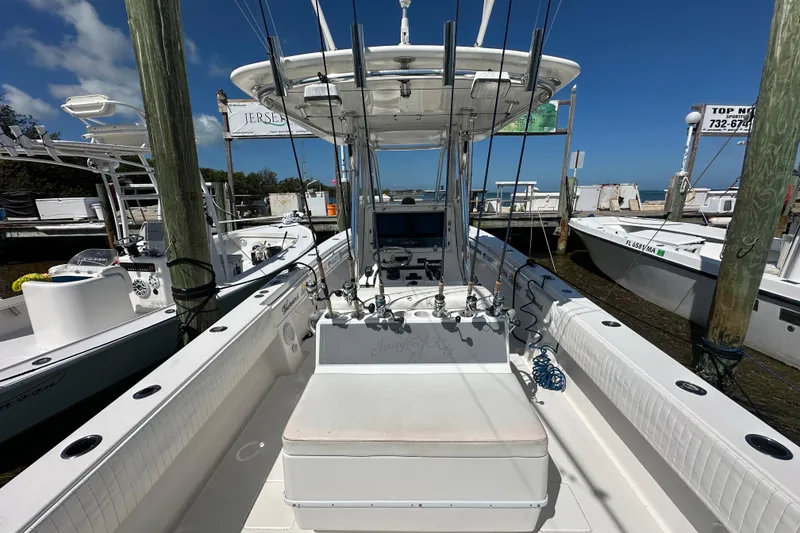 Slide: The Image of 2008 Contender 31 Tournament boat docked, featuring fishing rods and a spacious deck under clear skies. - 16