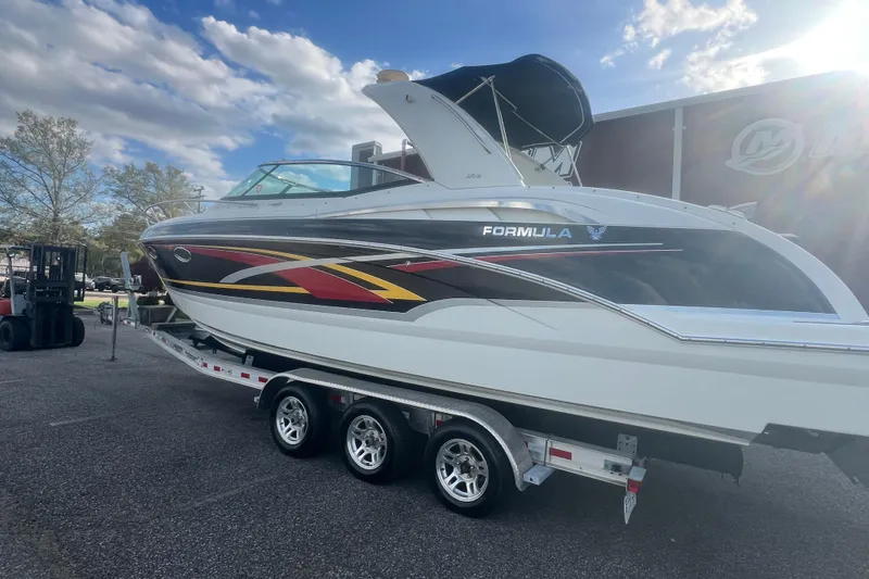 Slide: The Image of 2008 Formula 310 Sun Sport boat on trailer under a partly cloudy sky. - 2