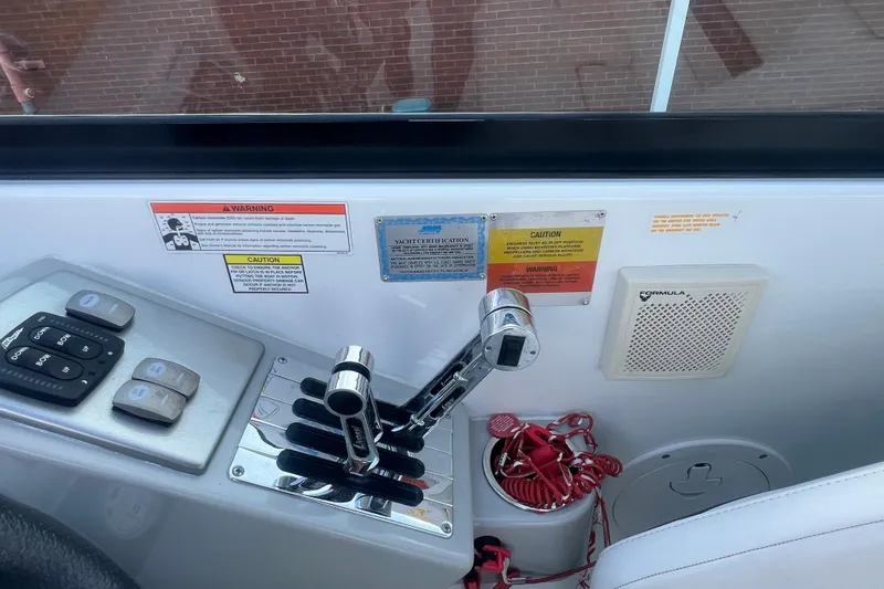 Slide: The Image of Control panel of a 2008 Formula 310 Sun Sport boat with throttle levers and warning labels. - 28