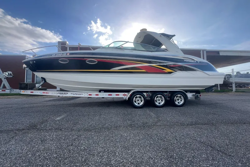 Slide: The Image of 2008 Formula 310 Sun Sport boat on trailer, vibrant design, parked outdoors. - 4