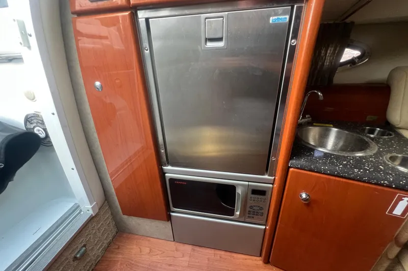 Slide: The Image of 2008 Formula 310 Sun Sport cabin with kitchenette, featuring fridge, microwave, and sink. - 45