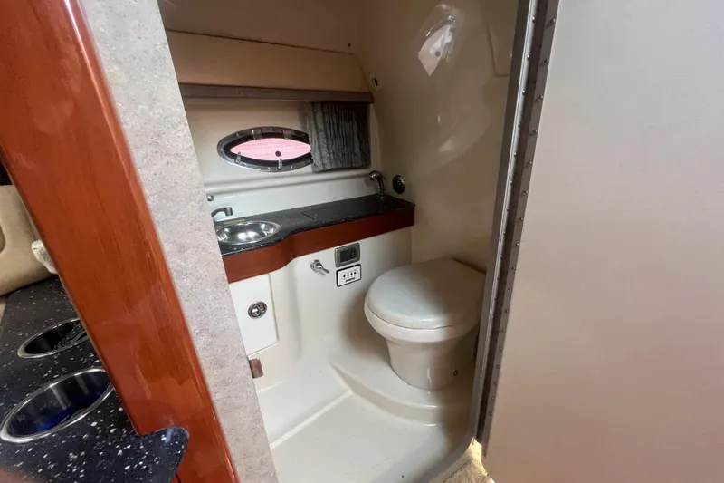 Slide: The Image of 2008 Formula 310 Sun Sport boat bathroom with sink, toilet, and porthole window. - 46