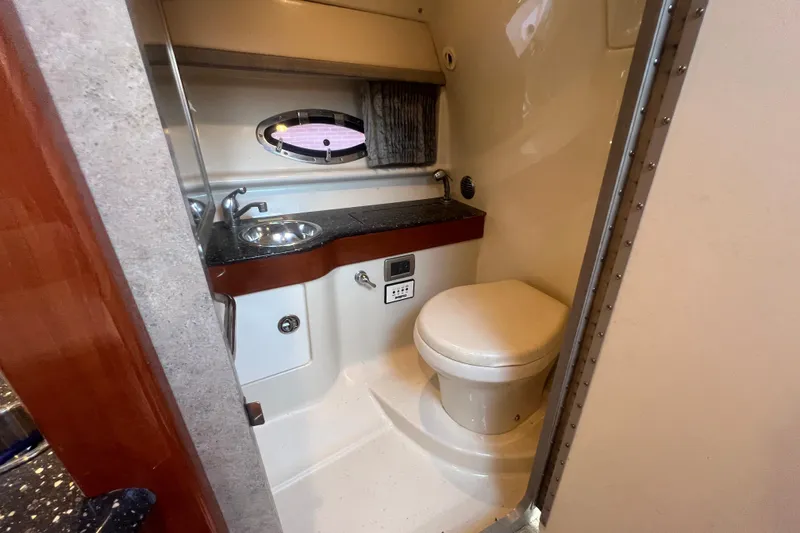 Slide: The Image of 2008 Formula 310 Sun Sport boat bathroom with sink, toilet, and porthole window. - 51