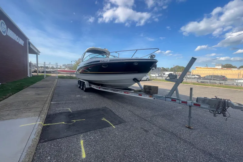Slide: The Image of 2008 Formula 310 Sun Sport boat on trailer, parked near a building under a blue sky. - 6