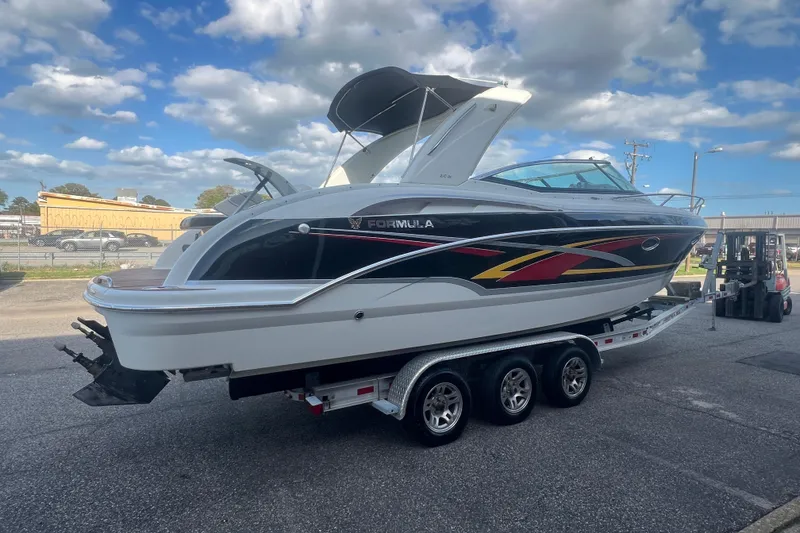 Slide: The Image of 2008 Formula 310 Sun Sport boat on trailer under a partly cloudy sky. - 9