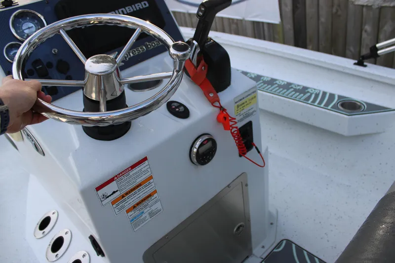 Slide: The Image of Steering console of 2021 Xpress H22B Bay boat with chrome wheel and control panel. - 11