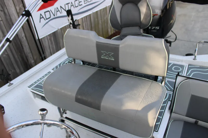 Slide: The Image of 2021 Xpress H22B Bay boat with gray seating and steering wheel detail. - 12