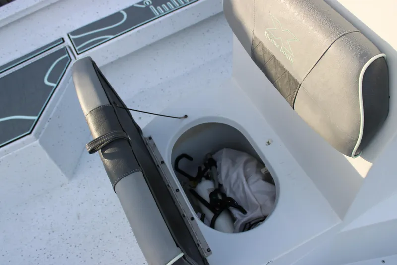 Slide: The Image of 2021 Xpress H22B Bay boat seat storage compartment with gear inside. - 8