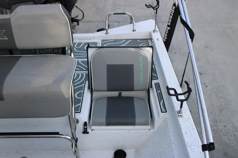Slide: The Image of 2021 Xpress H22B Bay boat interior with gray seating and rod holders. - 9