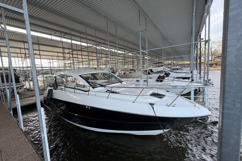 The Image of 2015 Cruisers Yachts 390 Express Coupe docked in a covered marina. - 1