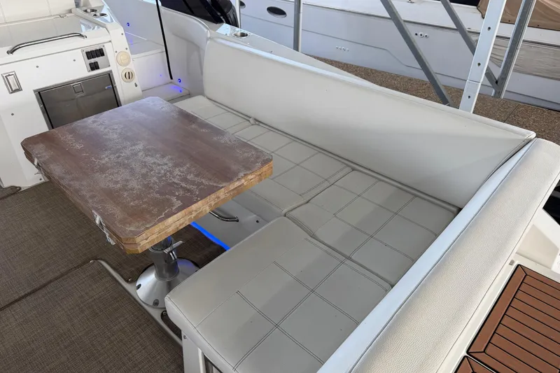 Slide: The Image of 2015 Cruisers Yachts 390 Express Coupe interior with cushioned seating and wooden table. - 5