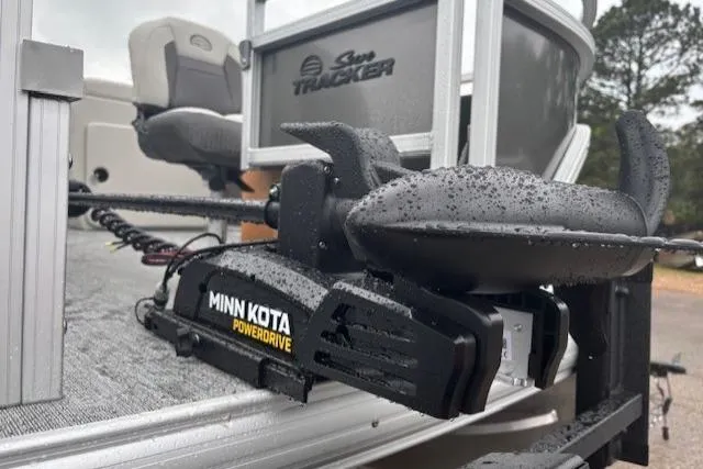 Slide: The Image of 2026 Sun Tracker Fishin' Barge 22 DLX with Minn Kota PowerDrive motor, wet from rain. - 11