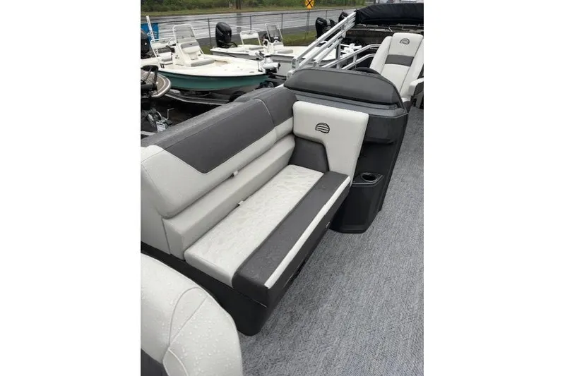 Slide: The Image of 2026 Sun Tracker Fishin' Barge 22 DLX interior seating with gray and white upholstery. - 14