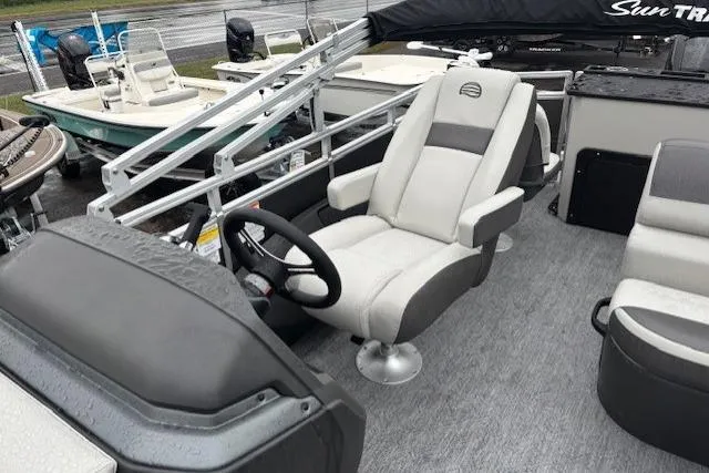 Slide: The Image of 2026 Sun Tracker Fishin' Barge 22 DLX interior with captain's chair and steering wheel. - 16