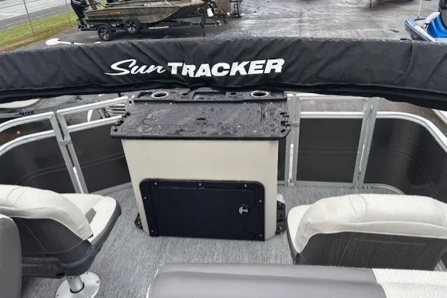 Slide: The Image of 2026 Sun Tracker Fishin' Barge 22 DLX interior with seating and covered console. - 17