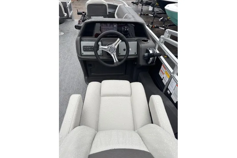 Slide: The Image of 2026 Sun Tracker Fishin' Barge 22 DLX interior with steering wheel and seating. - 20
