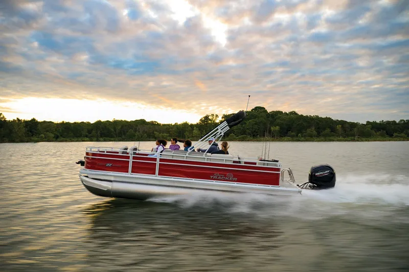 Slide: The Image of Manufacturer Provided Image: 2026 Sun Tracker Fishin' Barge 22 DLX cruising on a serene lake at sunset. - 25