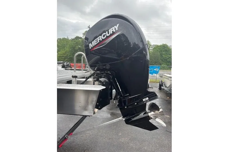 Slide: The Image of 2026 Sun Tracker Fishin' Barge 22 DLX with Mercury outboard motor, parked outdoors. - 3