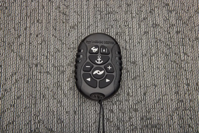 Slide: The Image of Manufacturer Provided Image: Remote control on textured surface, Sun Tracker Fishin' Barge 22 DLX 2026 model. - 50