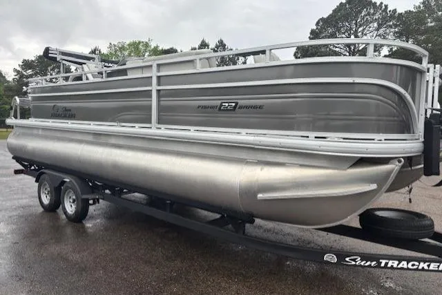Slide: The Image of 2026 Sun Tracker Fishin' Barge 22 DLX pontoon boat on trailer, parked outdoors. - 7