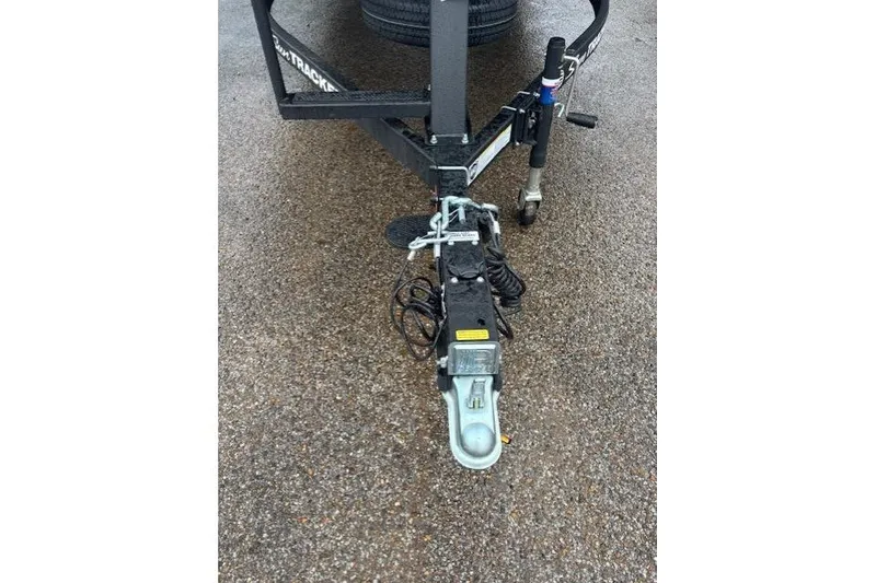 Slide: The Image of Trailer hitch of 2026 Sun Tracker Fishin' Barge 22 DLX on wet pavement. - 9