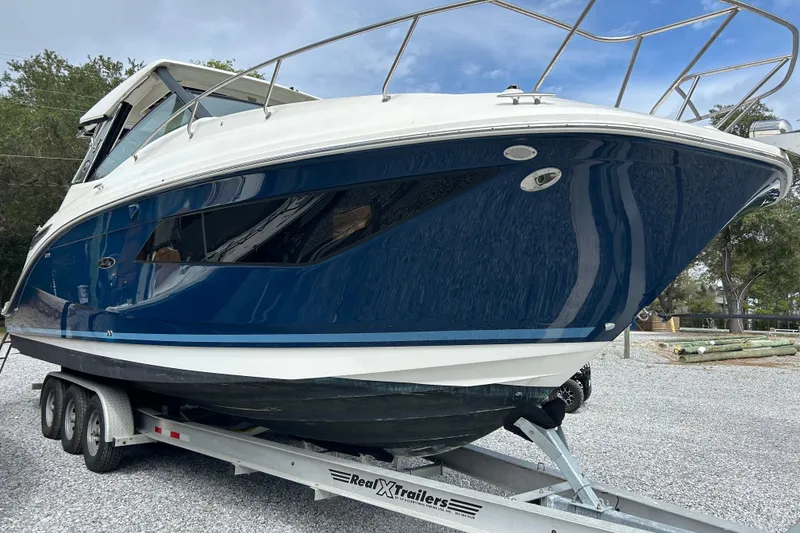 The Image of 2022 Sea Ray Sundancer 320 Outboard on trailer, sleek blue hull, ready for adventure. - 1